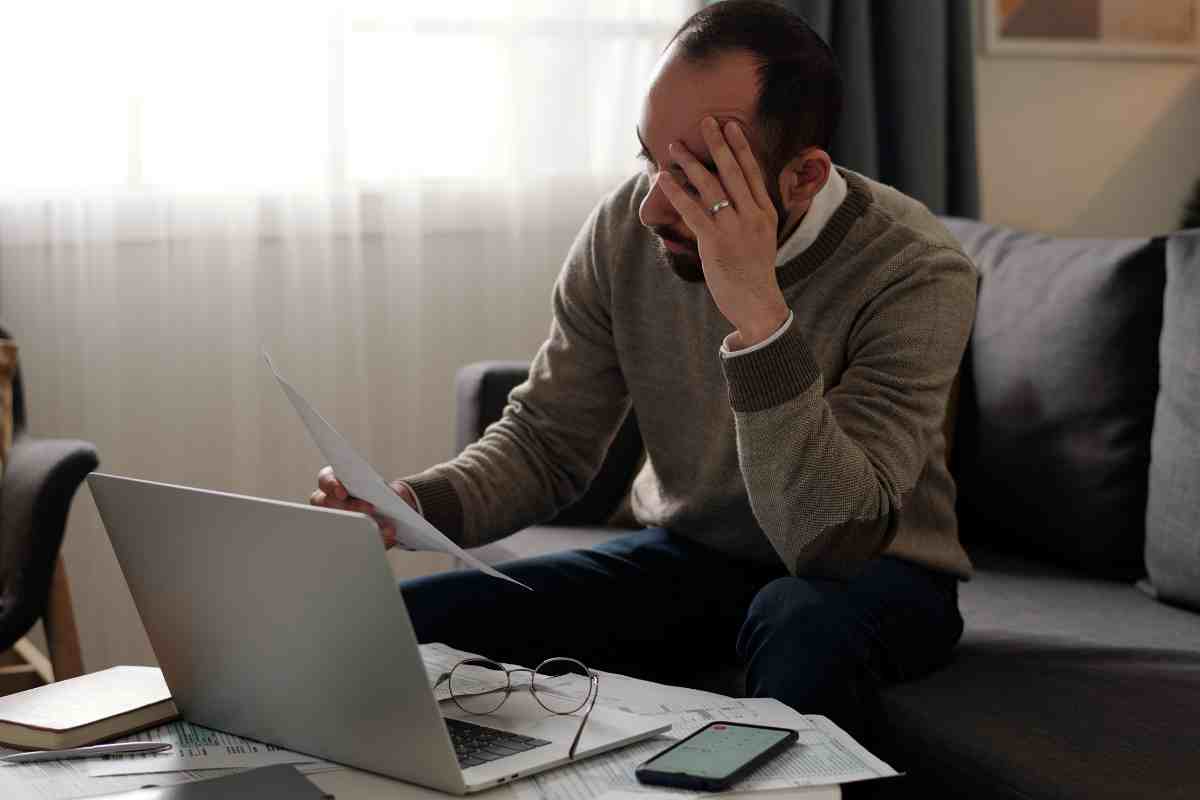 Uomo pensieroso davanti a dei documenti fiscali