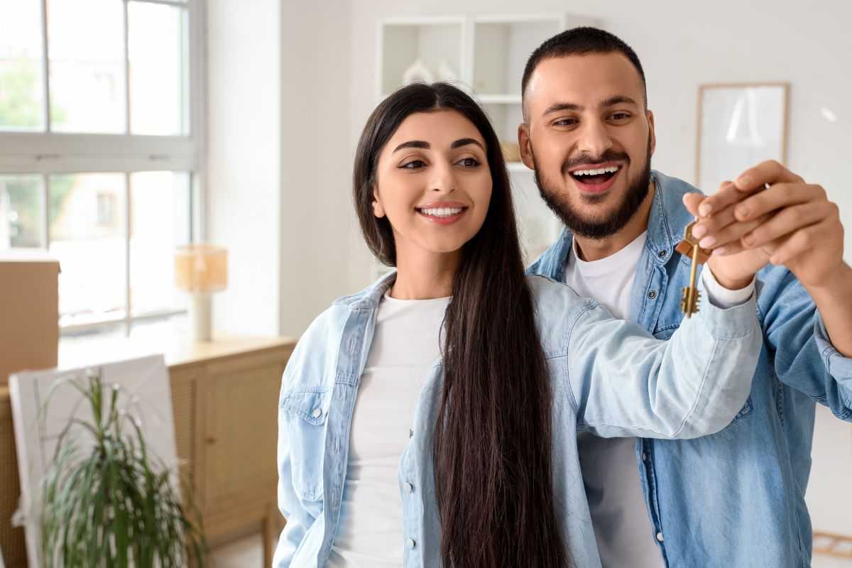 due giovani felici in casa con chiavi in mano