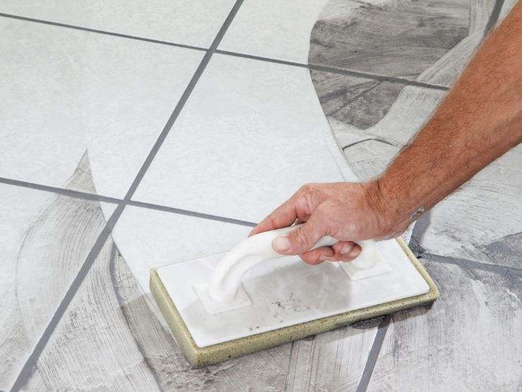 uomo che posa piastrelle