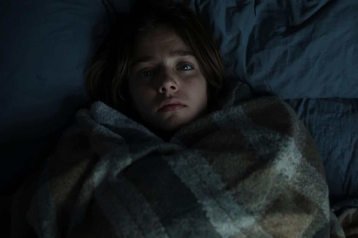 donna avvolta in una coperta che non riesce a dormire