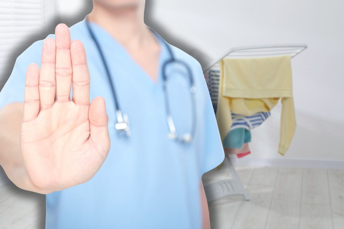 panni sullo stendino e medico che fa stop con le mani